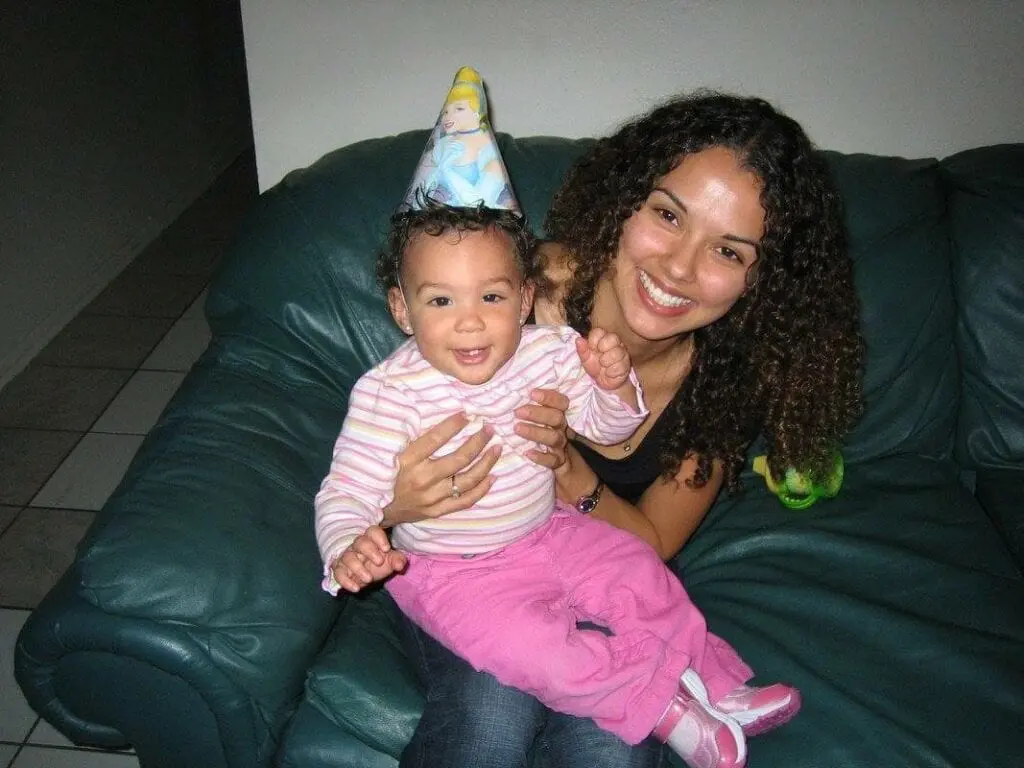 A Woman Posing With Her Baby On Birthday in Color Image
