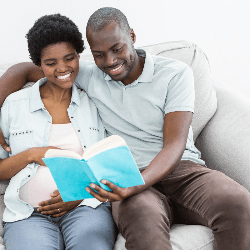 Picture of black pregnant woman with partner reading book