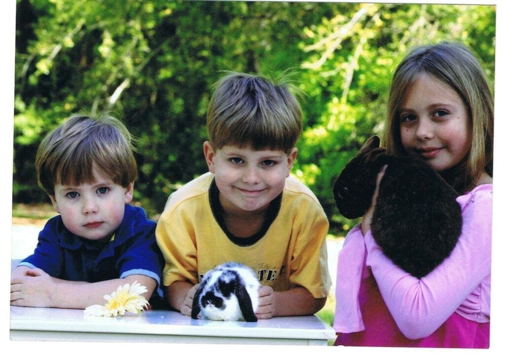 Three Children Posing With Their Pets in Color Image