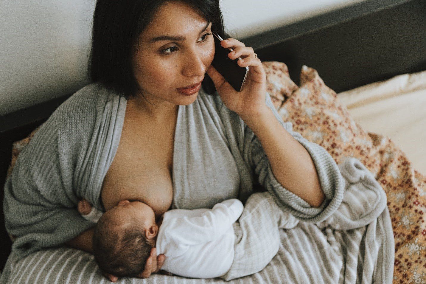 mother breastfeeding while on phone
