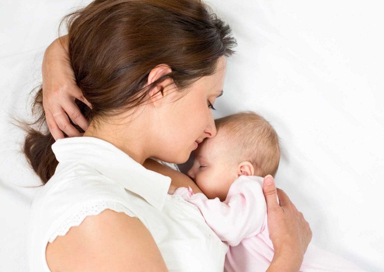 A mother lying on her side nursing her baby in the side-lying hold.
