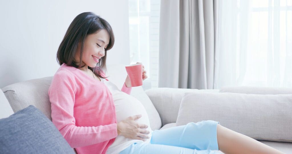 a pregnant woman looking at her baby bump