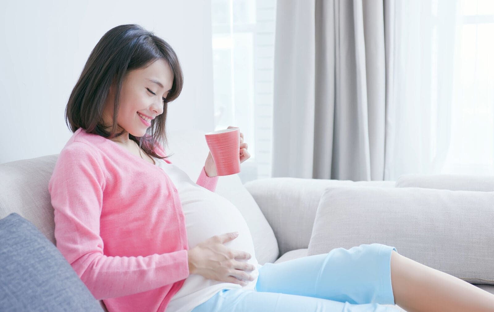 a pregnant woman looking at her baby bump