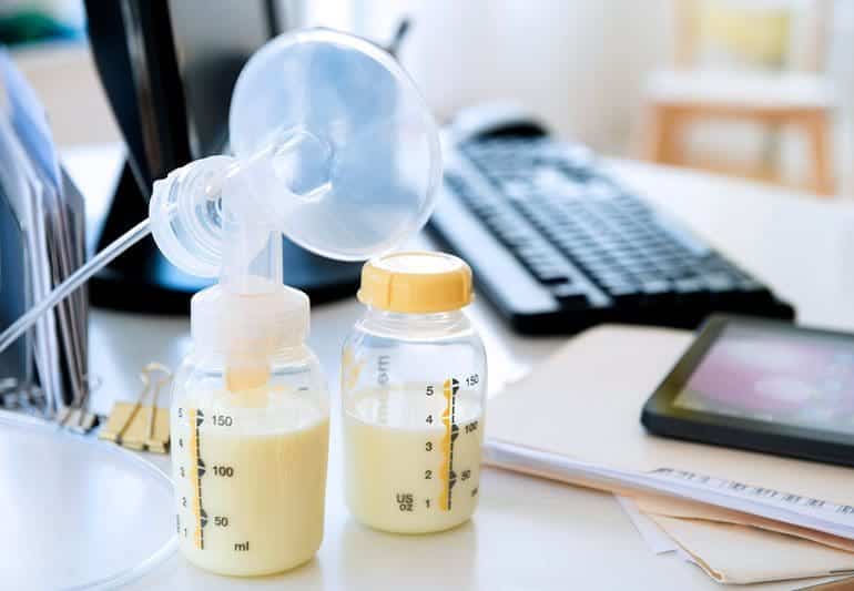 A breast pump set up on a desk in a workplace.