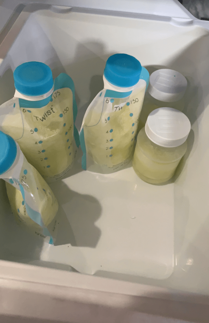 Bags of frozen breast milk stored flat in a freezer.
