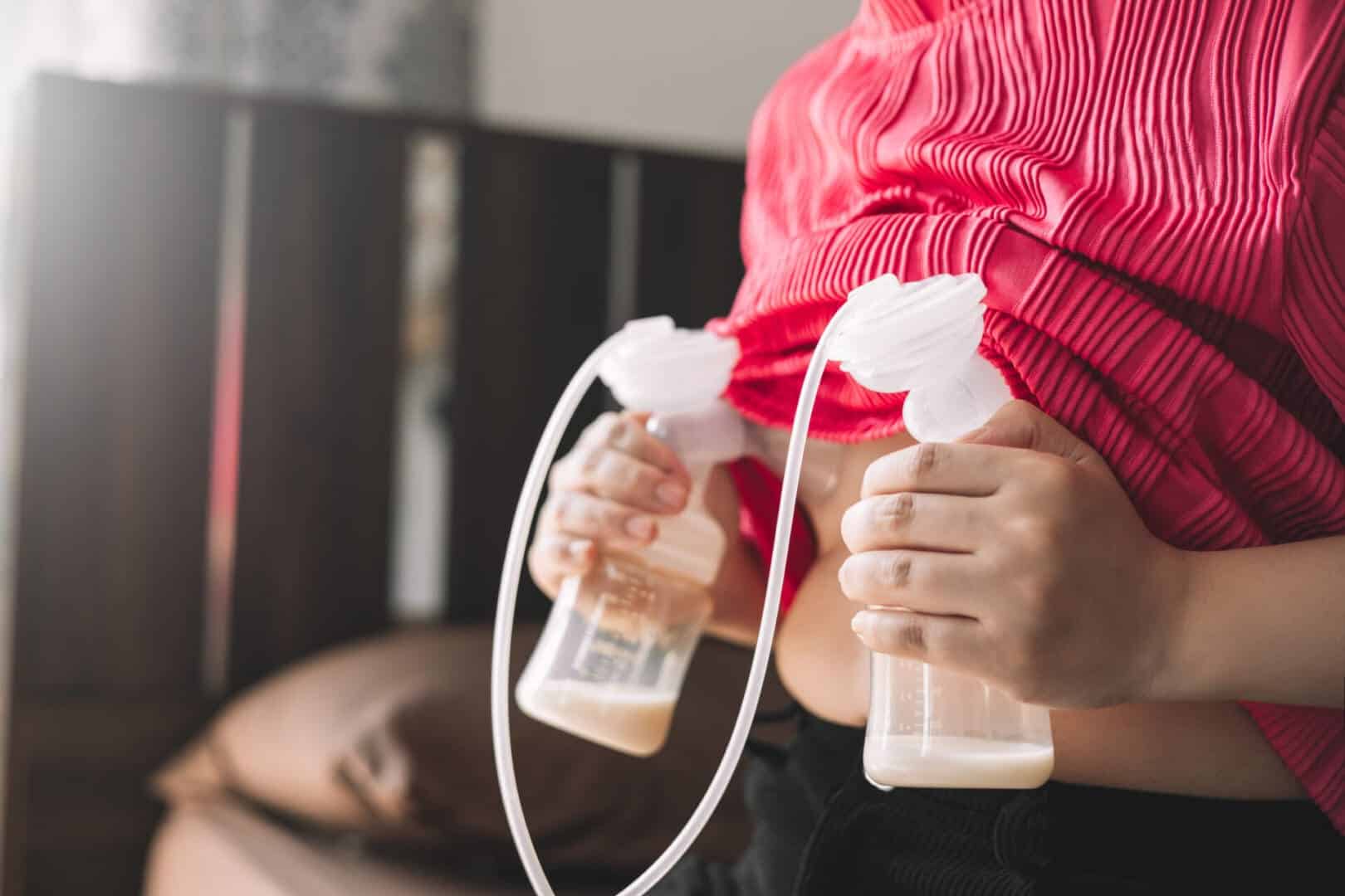 A mother expressing milk with an electric breast pump during an exclusive pumping session.