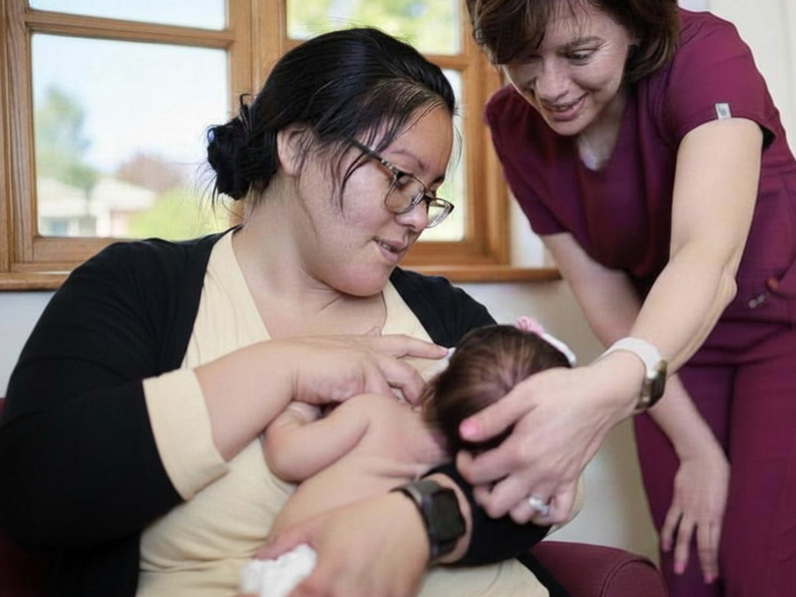 An IBCLC supporting a parent with latch and positioning during a breastfeeding consultation