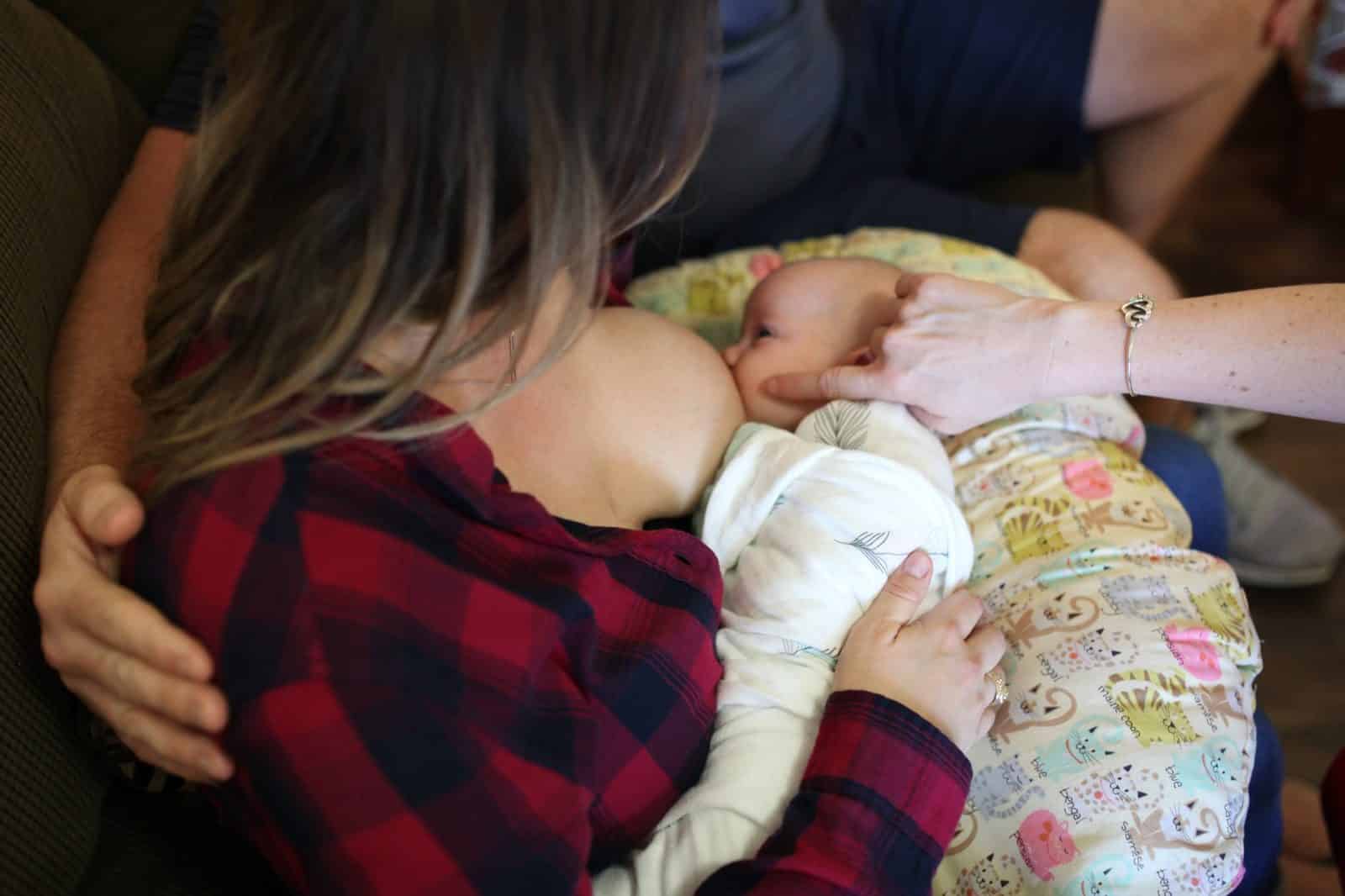 A lactation consultant showing a parent how to position and latch their baby.