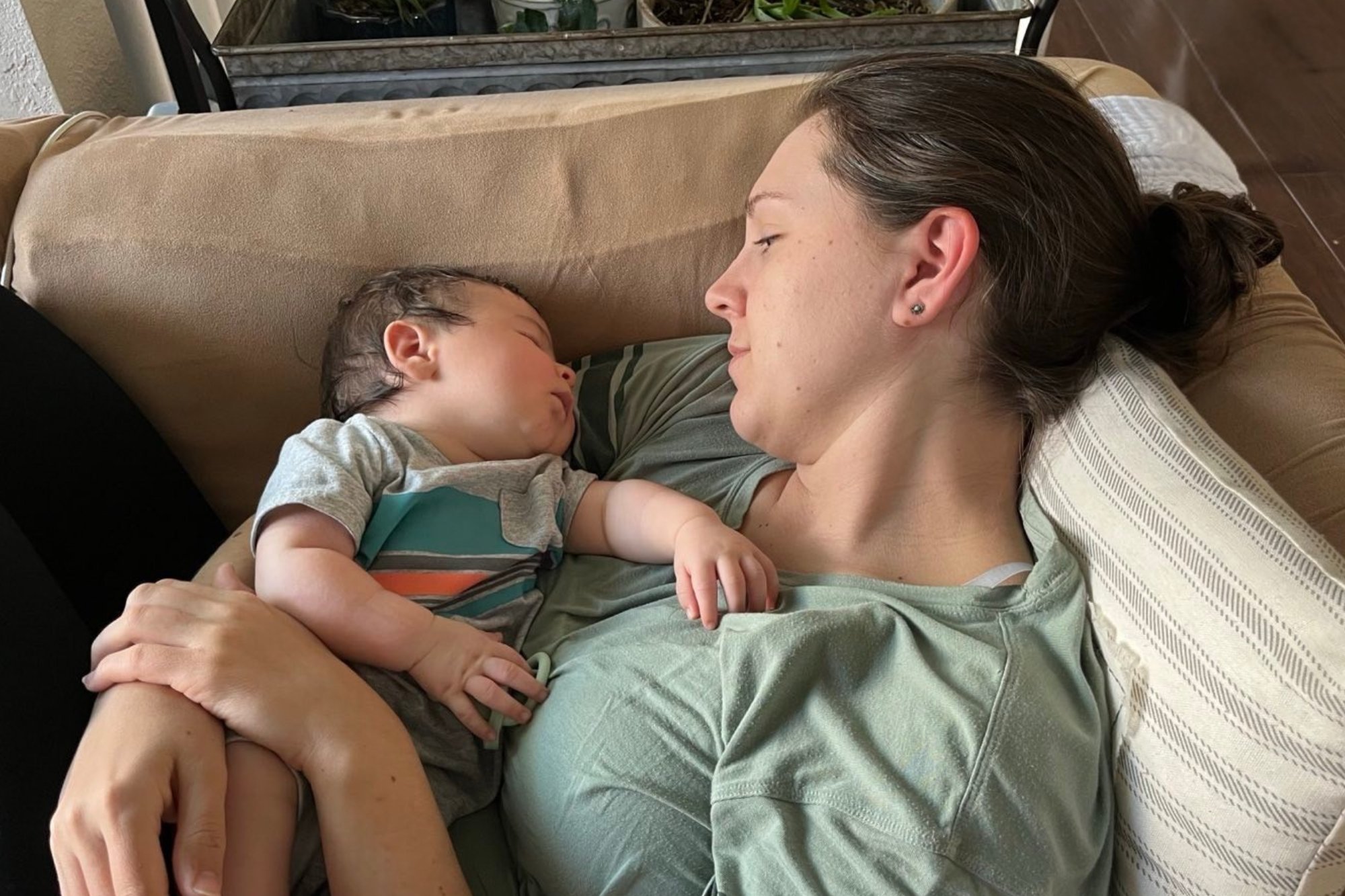 A parent holding and resting with their newborn