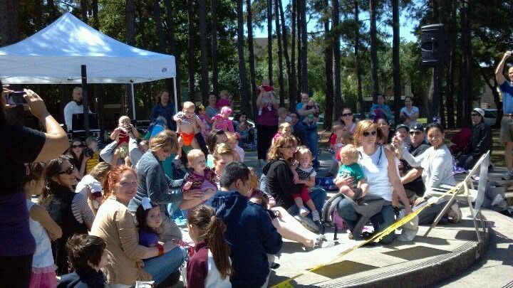 A group of parents breastfeeding their babies together at a community Big Latch On gathering.