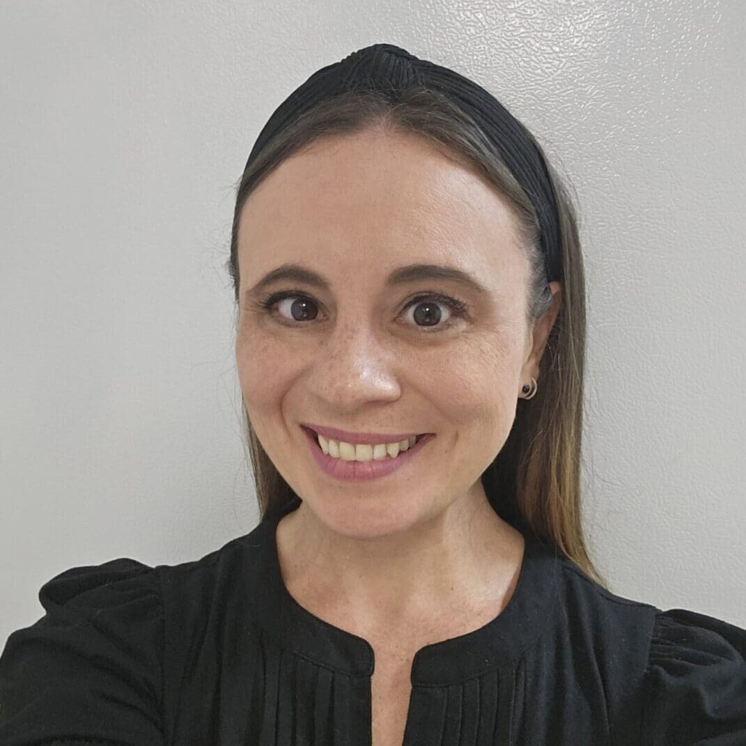 Joanna Patane-Hopkins - Headshot Woman in black top and headband smiling.
