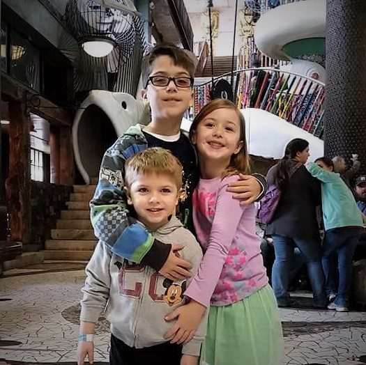 A family of five posing together outdoors.
