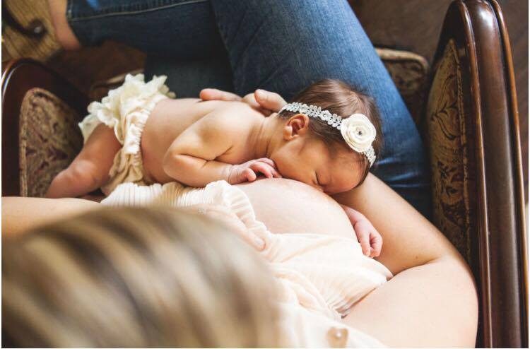 A close-up of a sleeping newborn on a soft blanket.