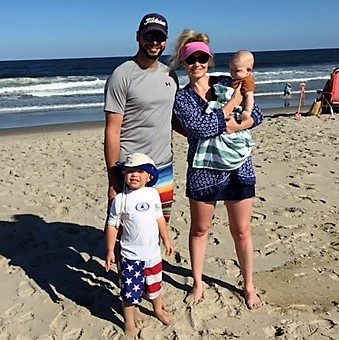 A family standing together on the beach.