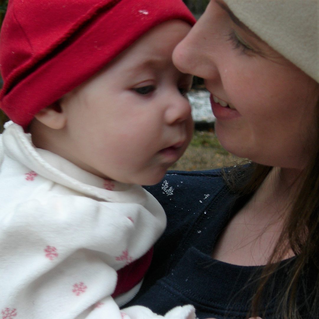 A mother holding her baby against her shoulder.