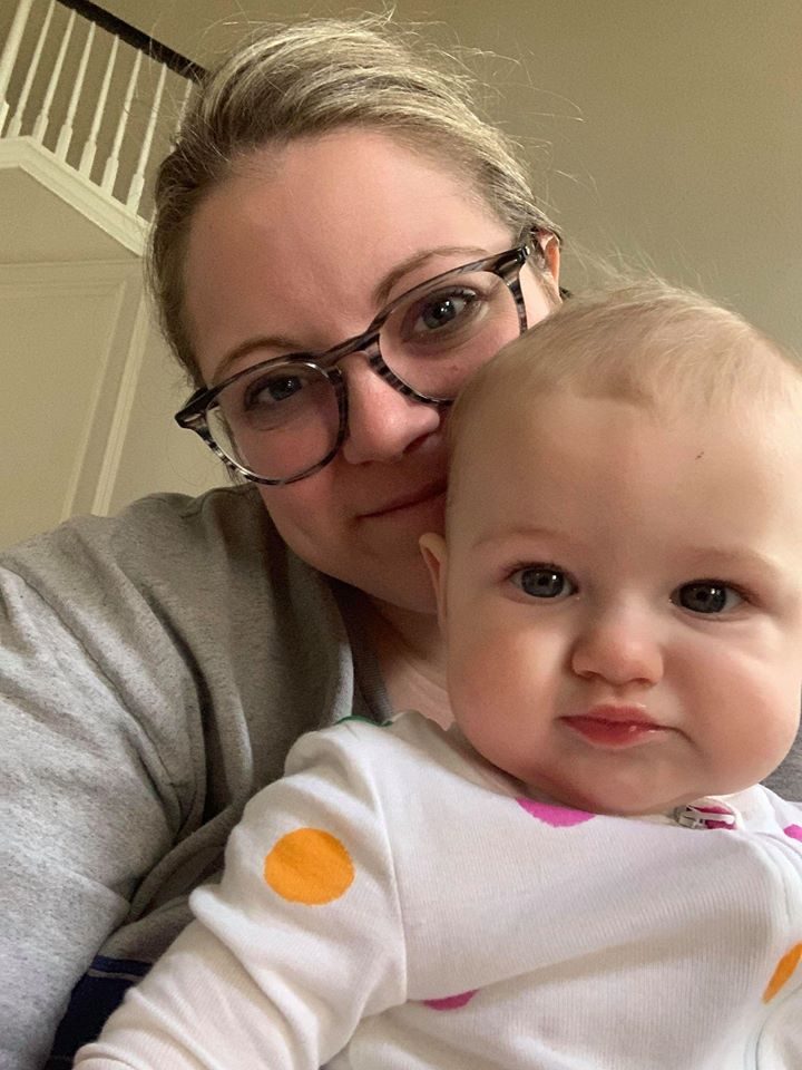 A mother holding her smiling baby cheek to cheek.