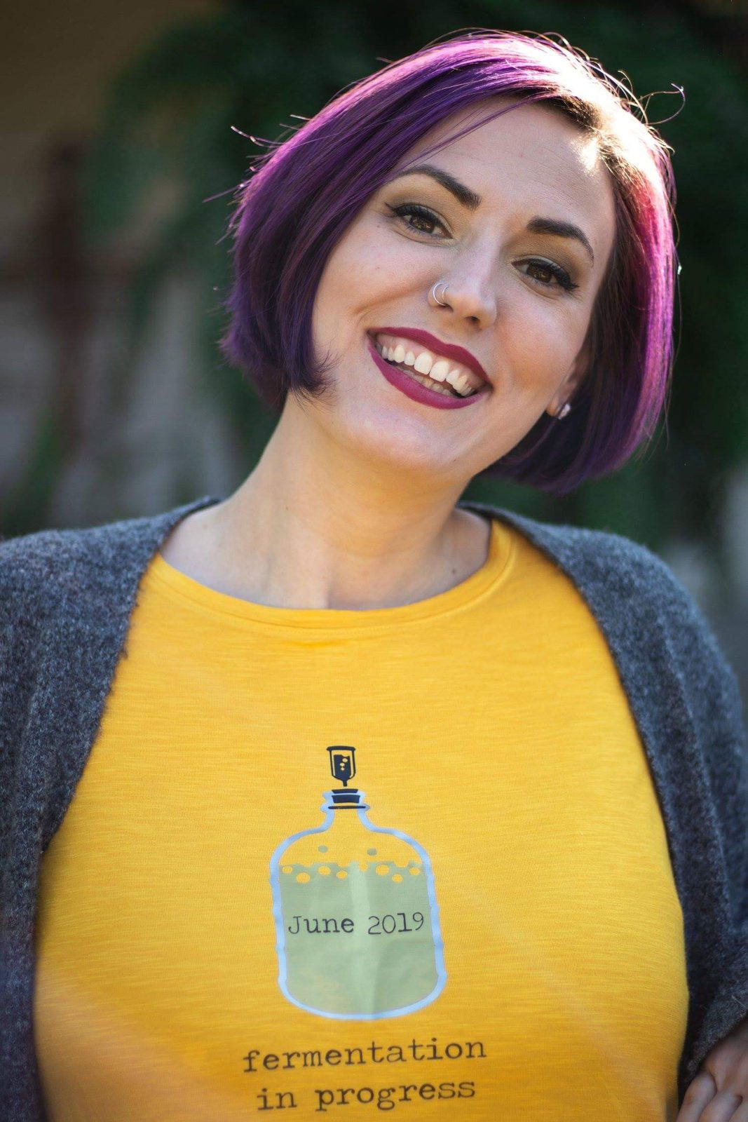A smiling mother with brightly colored hair.