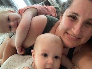 A mother smiling cheek to cheek with her baby.