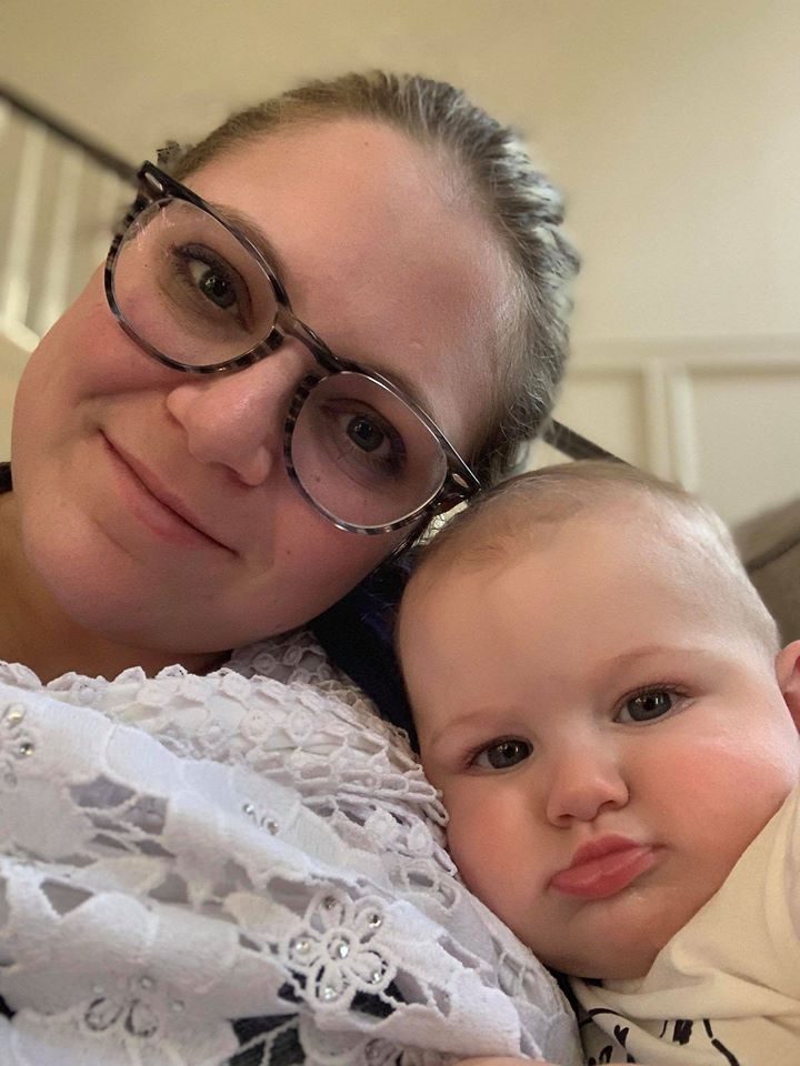 A mother nuzzling her baby close in her arms.