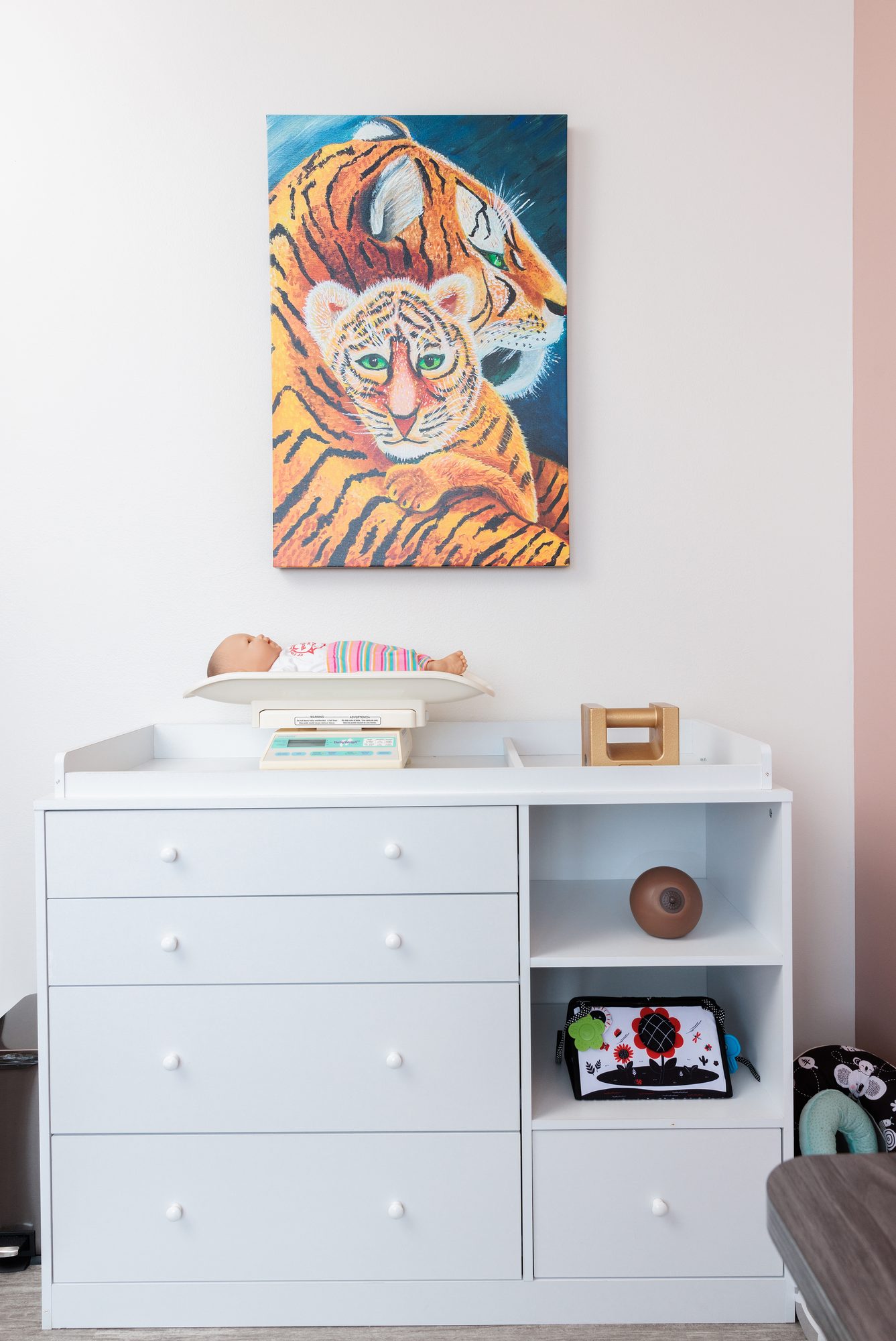 A hand-painted tiger and her cub on the wall above an infant scale